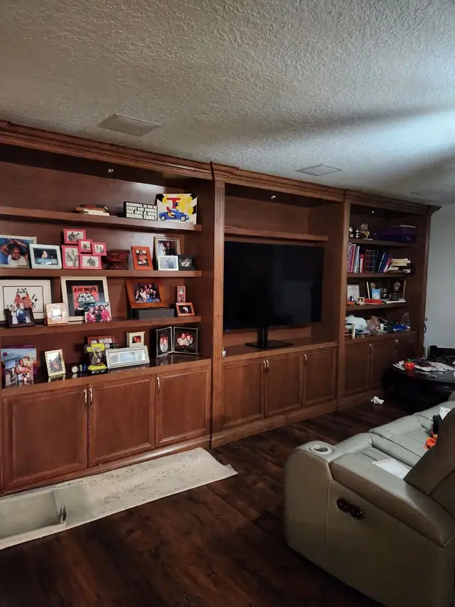 Before: large dark cherry wood wall unit with TV opening, display shelves and lower cabinets